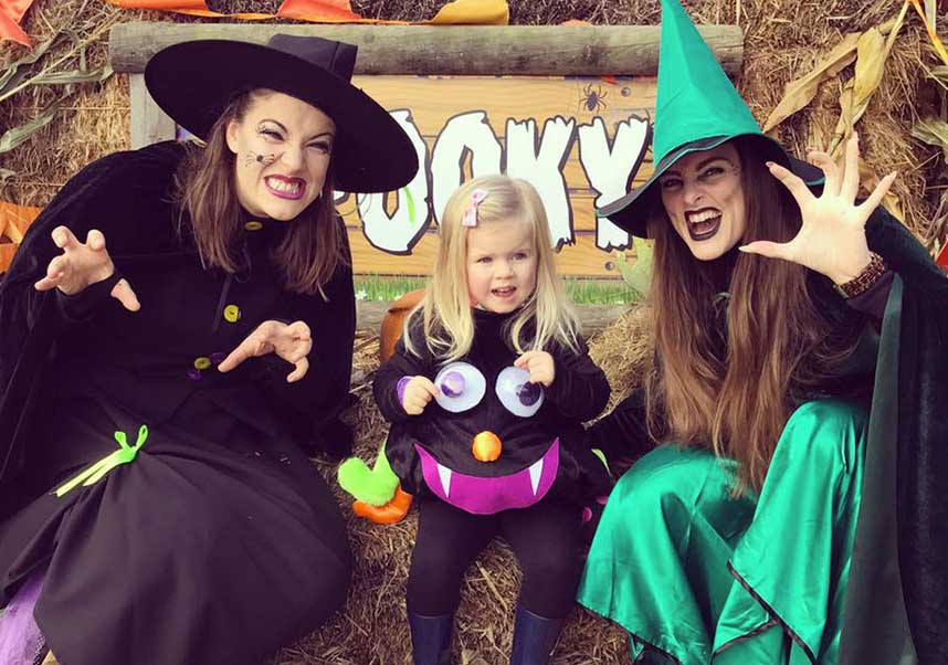 Witches posing with a little girl